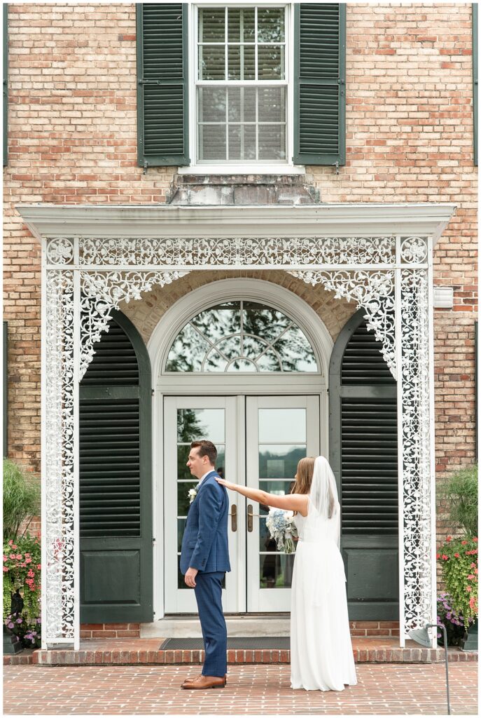 bride tapping her groom on his shoulder from behind for first look moment at this Drumore Estate Summer Wedding