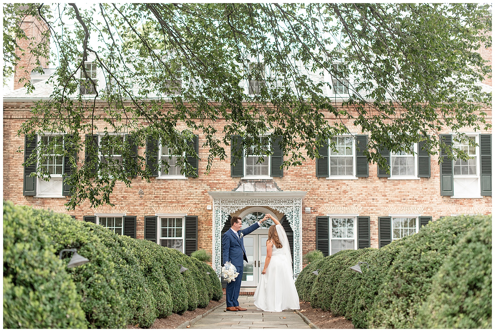 groom twirling his bride by front door of drumore estate at this lancaster county wedding