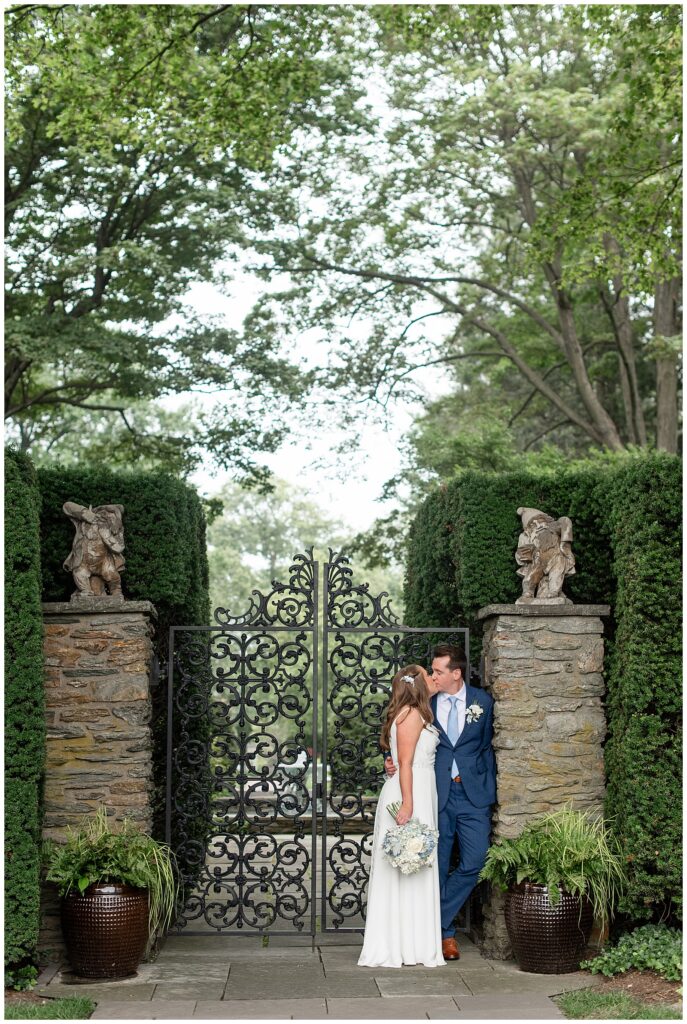couple kissing by entrance gate at this Drumore Estate Summer Wedding in lancaster county