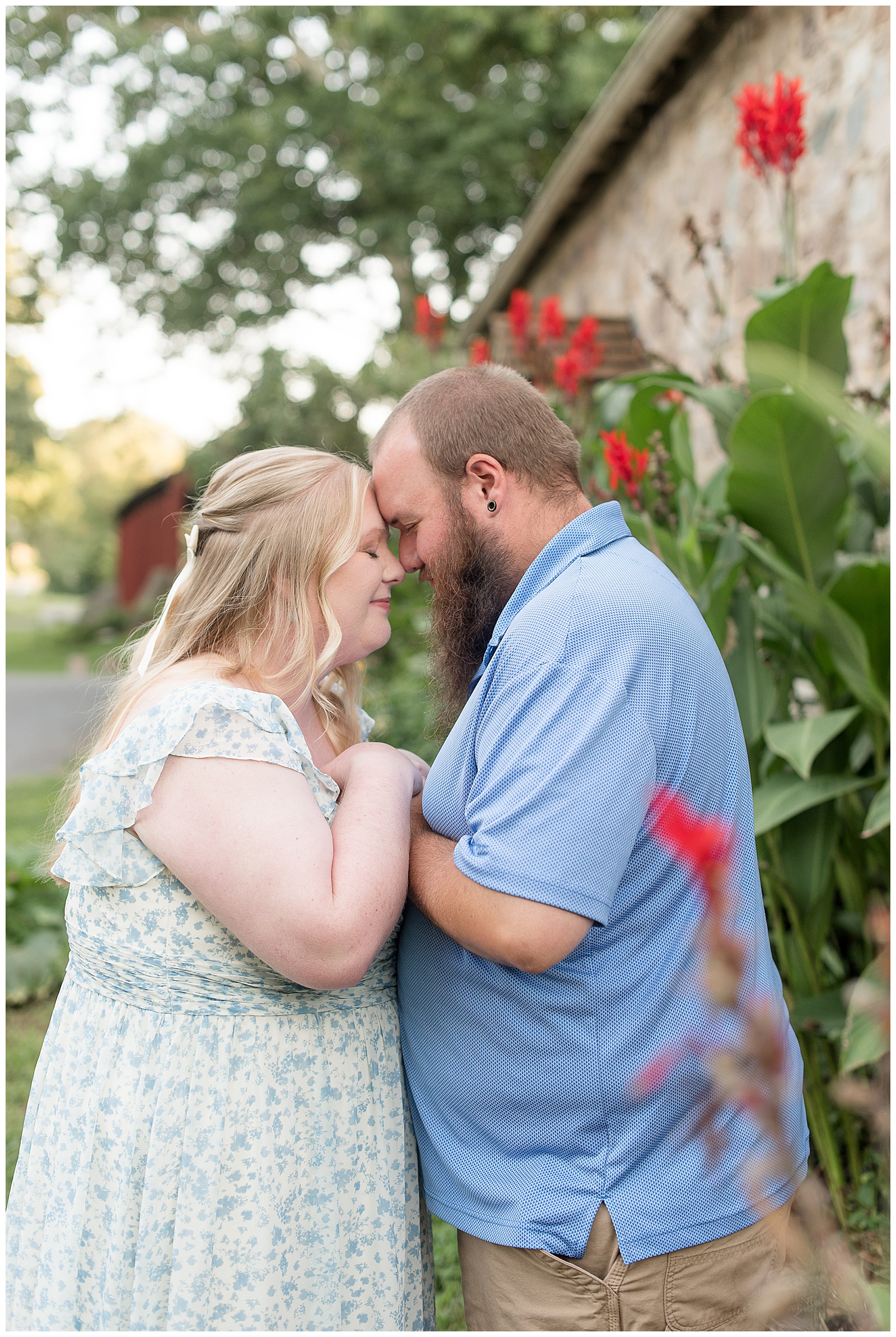 couple resting their foreheads together by cana lilies at this Historic Poole Forge Summer Engagement Session