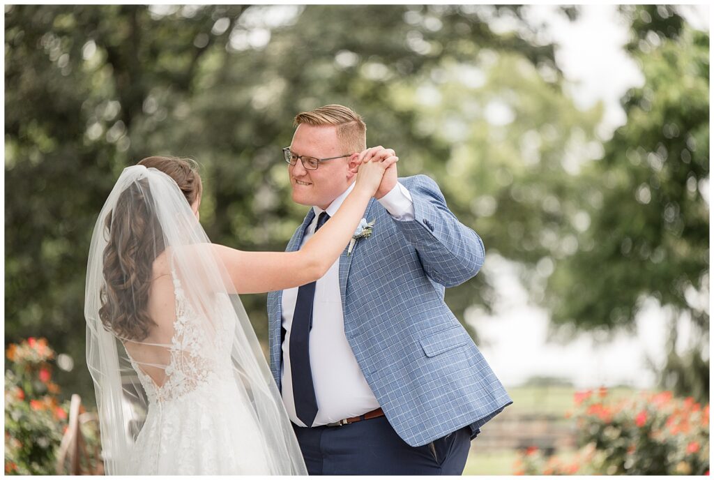 bride and groom sharing fun first look moment as they join hands for this Lakeview Farms Summer Wedding