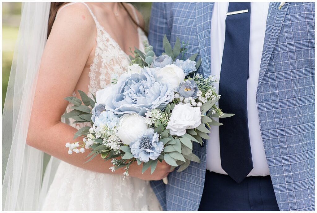 closeup photo of bride and groom with bouquet of blue and white flowers and eucalyptus at this Lakeview Farms Summer Wedding