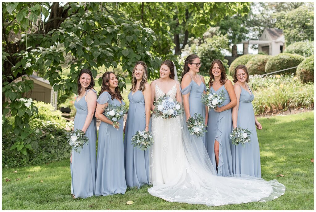 bride with her six bridesmaids in light blue gowns at this Lakeview Farms Summer Wedding