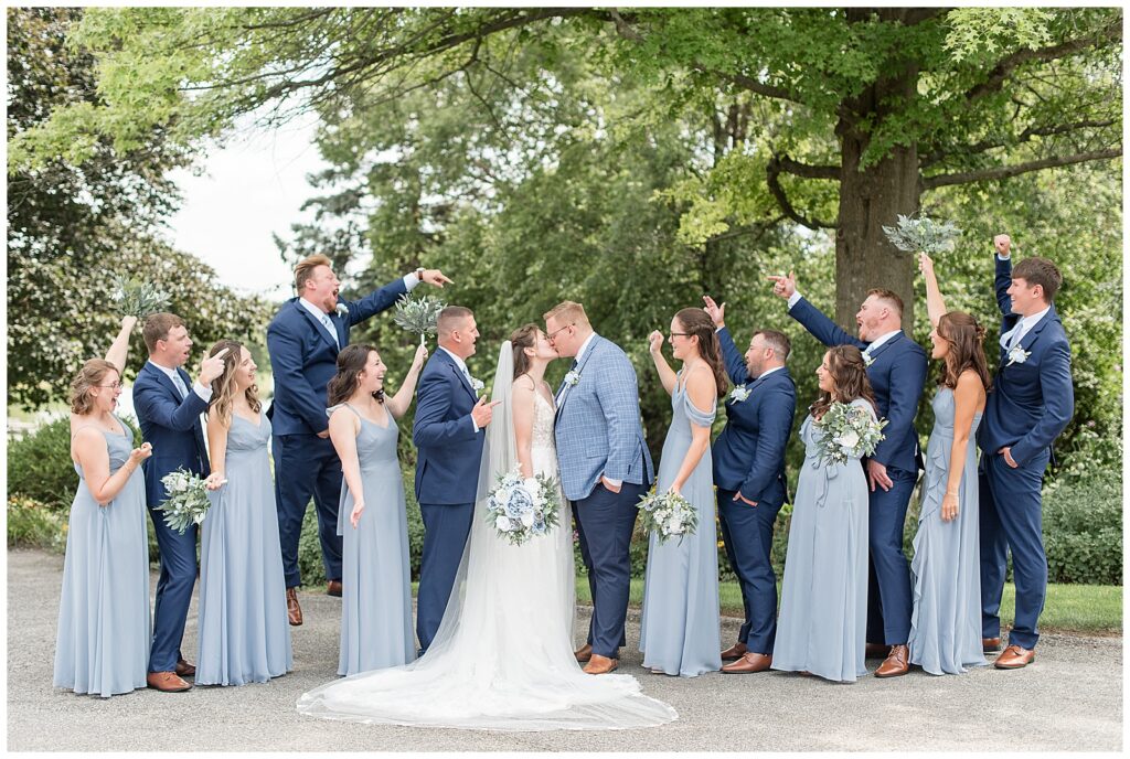 couple surrounded by their cheering bridal party as they kiss in dover pennsylvania
