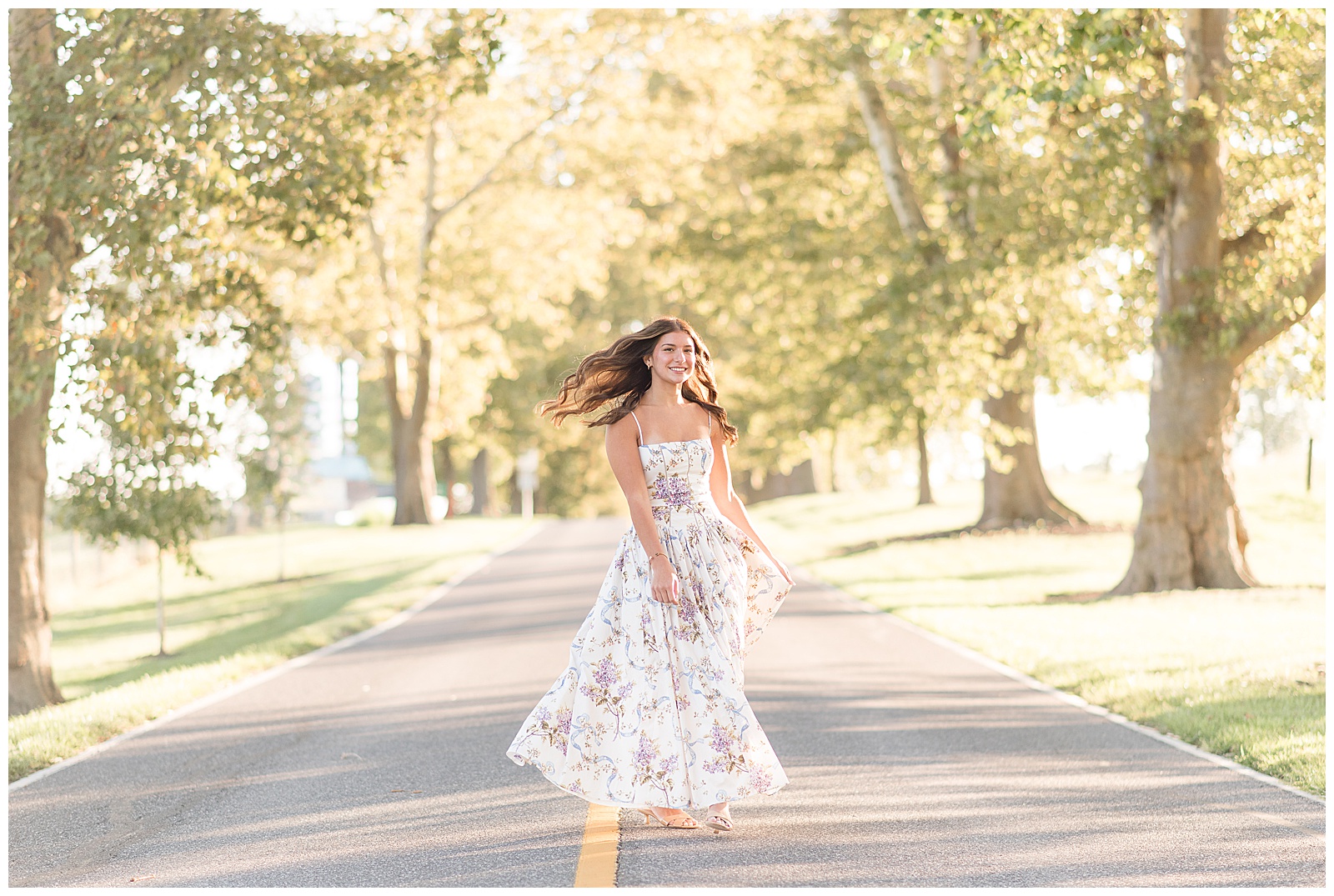 senior girl in floral dress spinning in middle of road for this Summer Masonic Village Senior Session