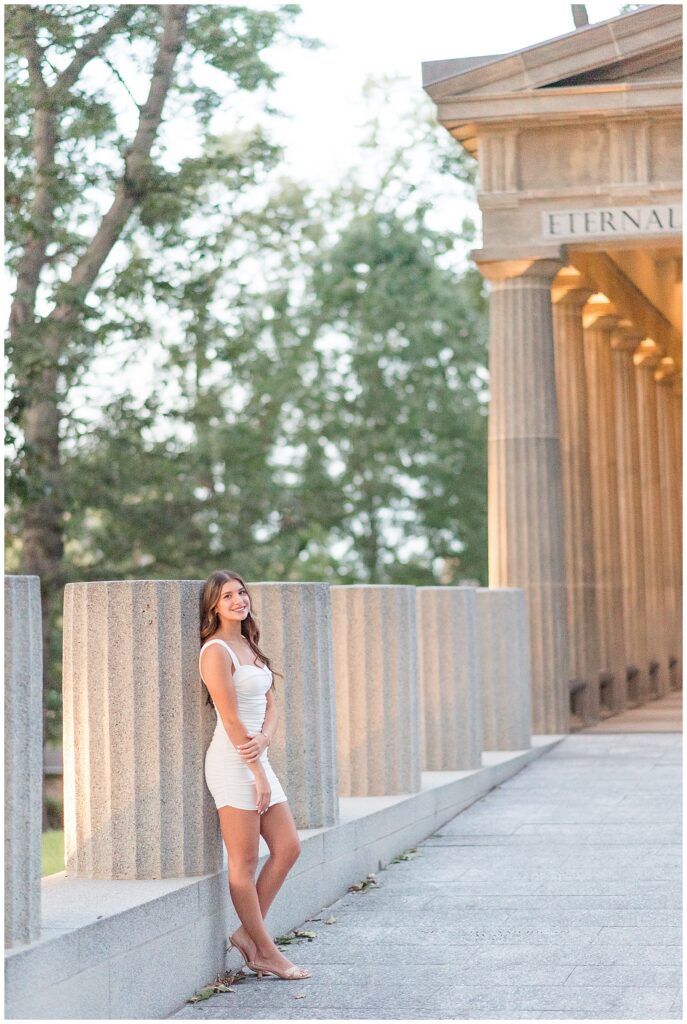 senior girl standing by concrete columns at masonic village in lancaster county pennsylvania