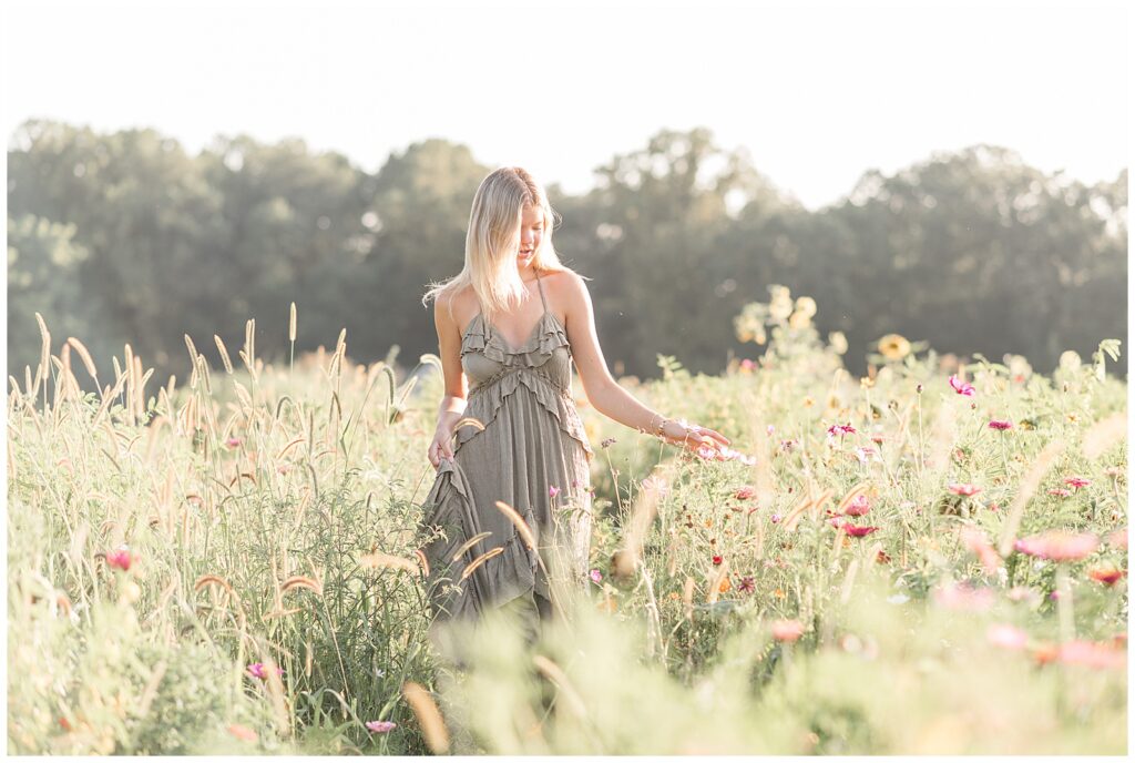senior girl in sage green flowy dress at sunset for this Summer Wildflower Field Senior Session