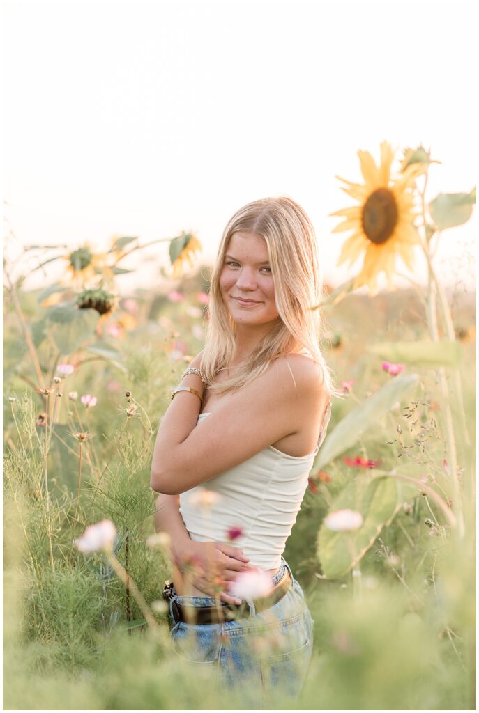 senior girl by tall sunflowers in lancaster pennsylvania for this Summer Wildflower Field Senior Session