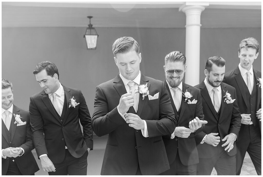black and white photo of groom and groomsmen candidly posing for this Elizabeth Furnace Fall Wedding