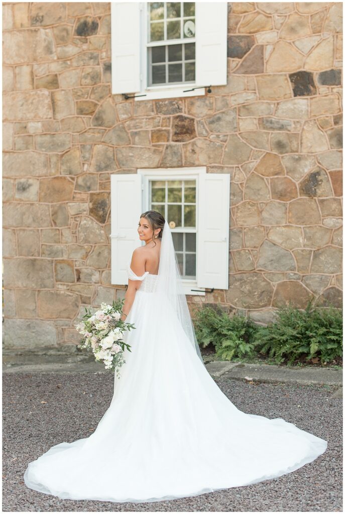 bride with back toward camera displaying her dress train and long veil for this Elizabeth Furnace Fall Wedding