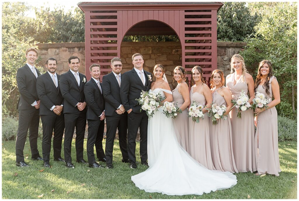 couple with their full bridal party by maroon building at this Elizabeth Furnace Fall Wedding