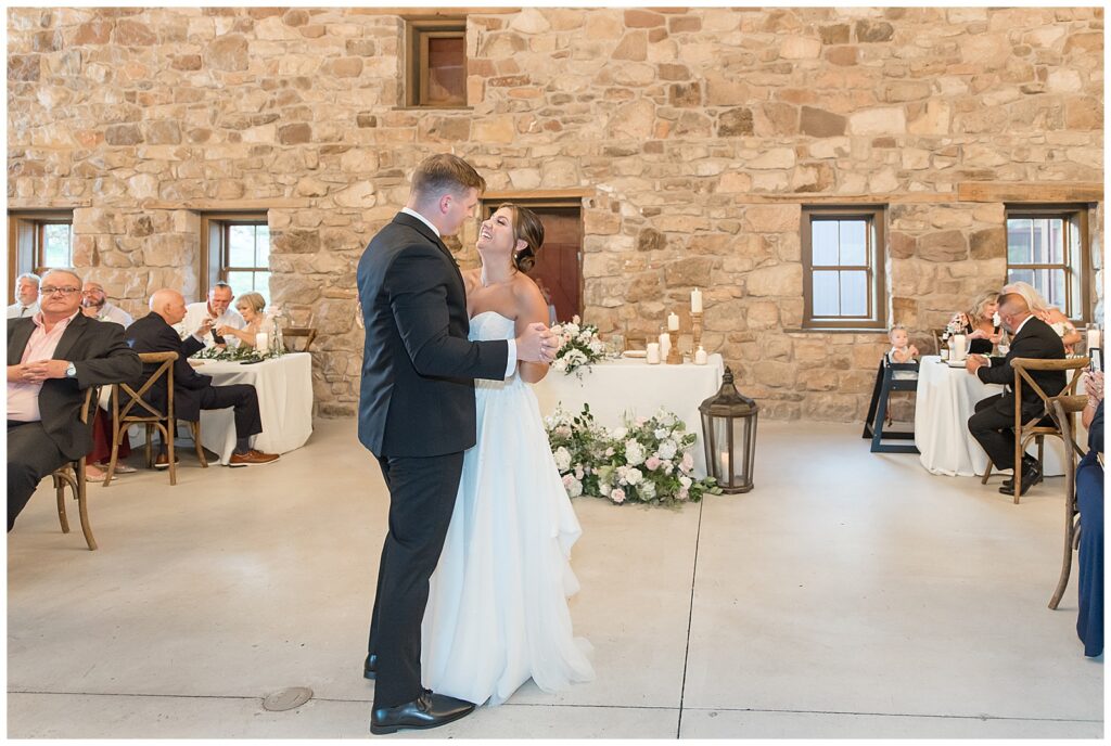 couple sharing their first dance inside beautiful stone barn wedding reception at this Elizabeth Furnace Fall Wedding