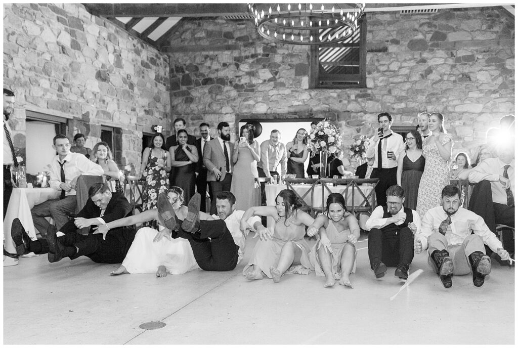black and white photo of guests having fun times during wedding reception for this Elizabeth Furnace Fall Wedding