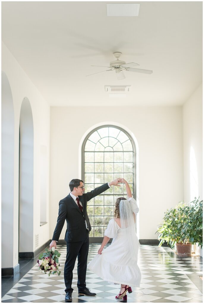 guy twirling girl under his left arm inside home at this Conestoga House and Gardens Engagement Session