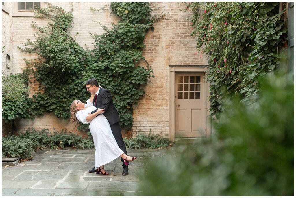 guy dipping girl back by ivy-covered building for this Conestoga House and Gardens Engagement Session
