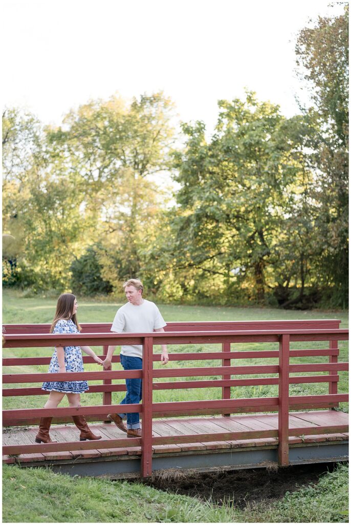 engaged couple holding hands and walking along fence for this Downtown Bethlehem Engagement Session
