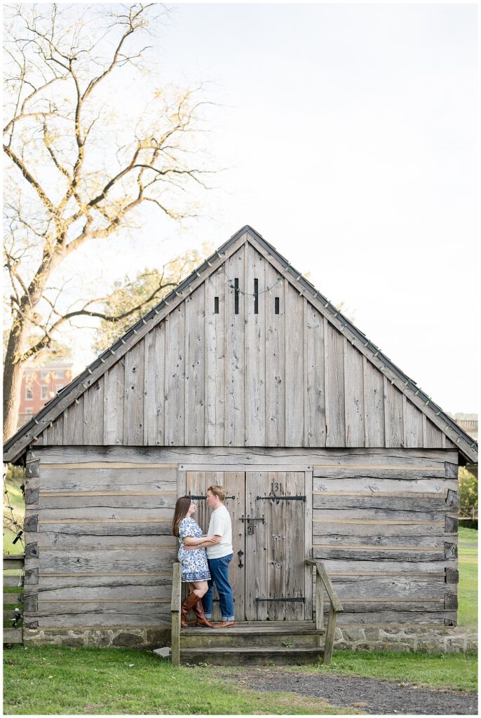 couple hugging by old wooden log cabin for this Downtown Bethlehem Engagement Session