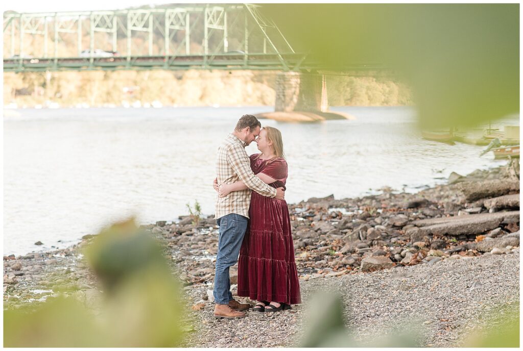 couple hugging by river with foreheads touching for this Downtown New Hope Engagement Session