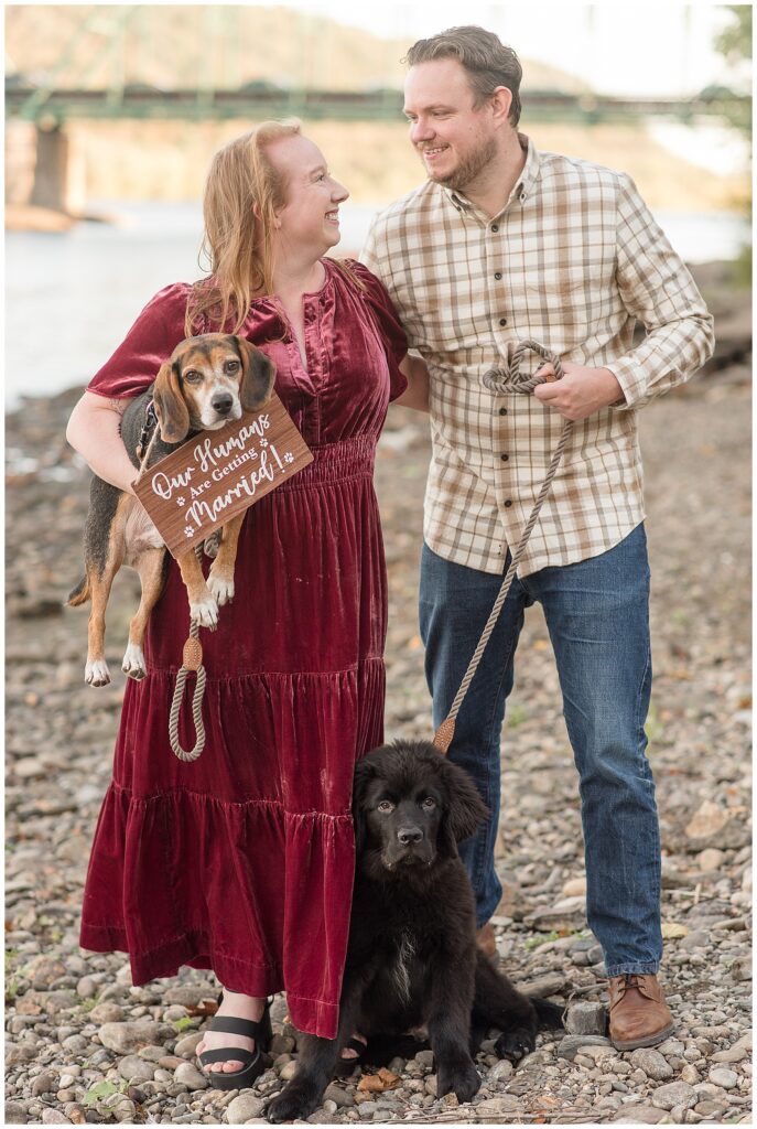 bride to be holding dog while groom to be hold its leash for this Downtown New Hope Engagement Session