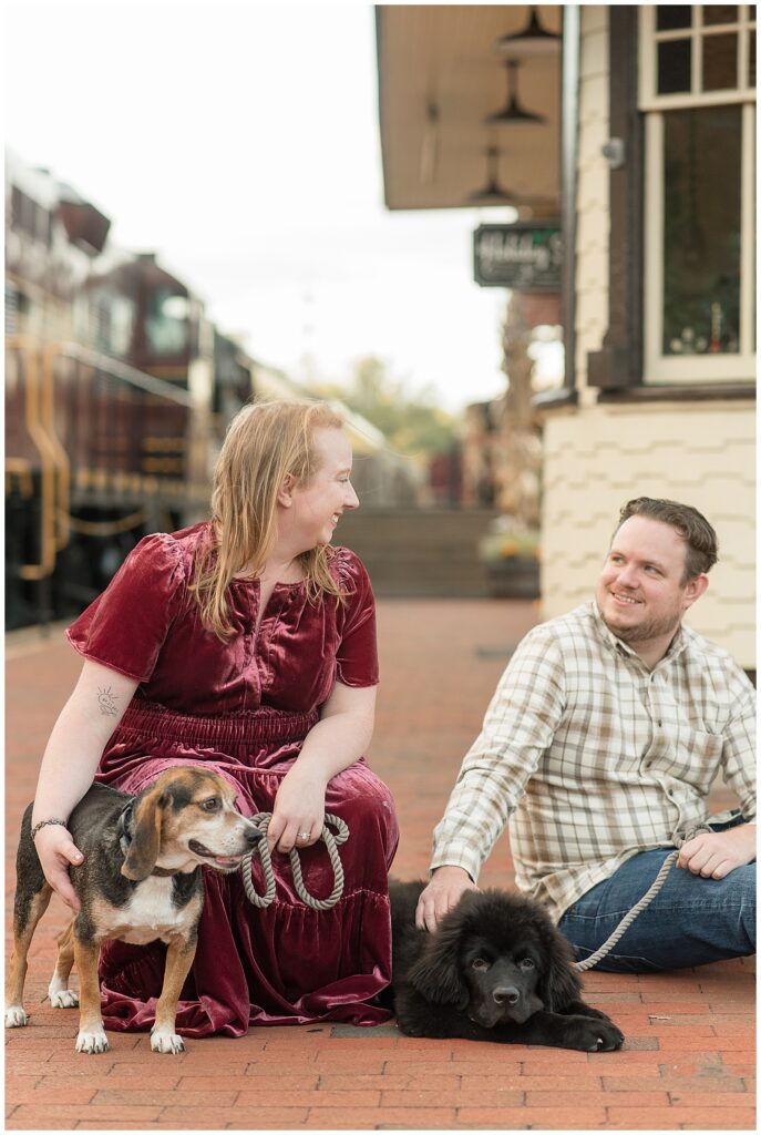 woman in maroon velvet dress and man in flannel shirt and jeans for this Downtown New Hope Engagement Session
