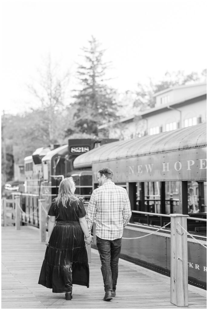 black and white photo of couple holding hands and walking away from camera for this Downtown New Hope Engagement Session