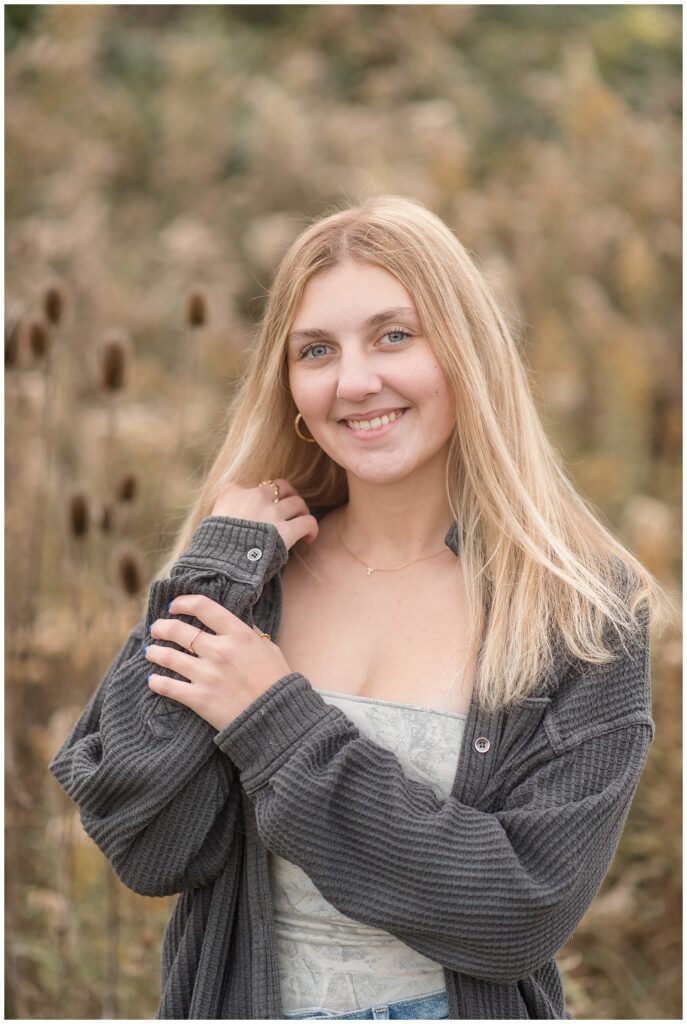 senior girl standing in field of dried wildflowers for this Fall Overlook Park Senior Session in lancaster county