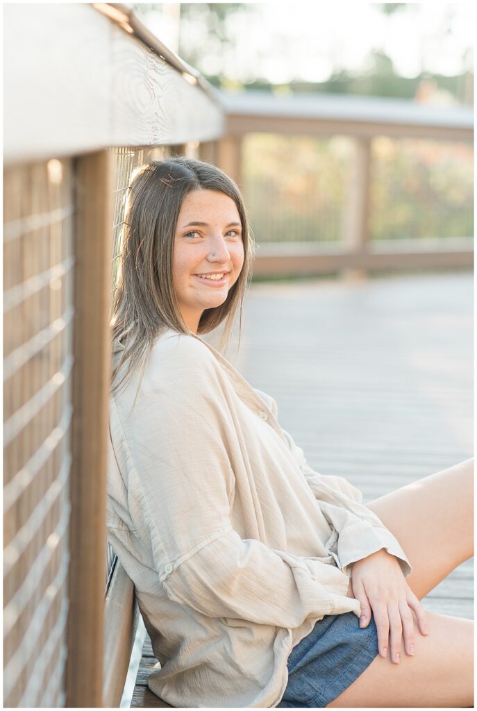 senior girl sitting against brick wall for this Longs Park Fall Senior Session in lancaster county pennsylvania