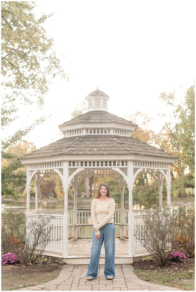 senior girl standing by white gazebo at sunset for this Longs Park Fall Senior Session