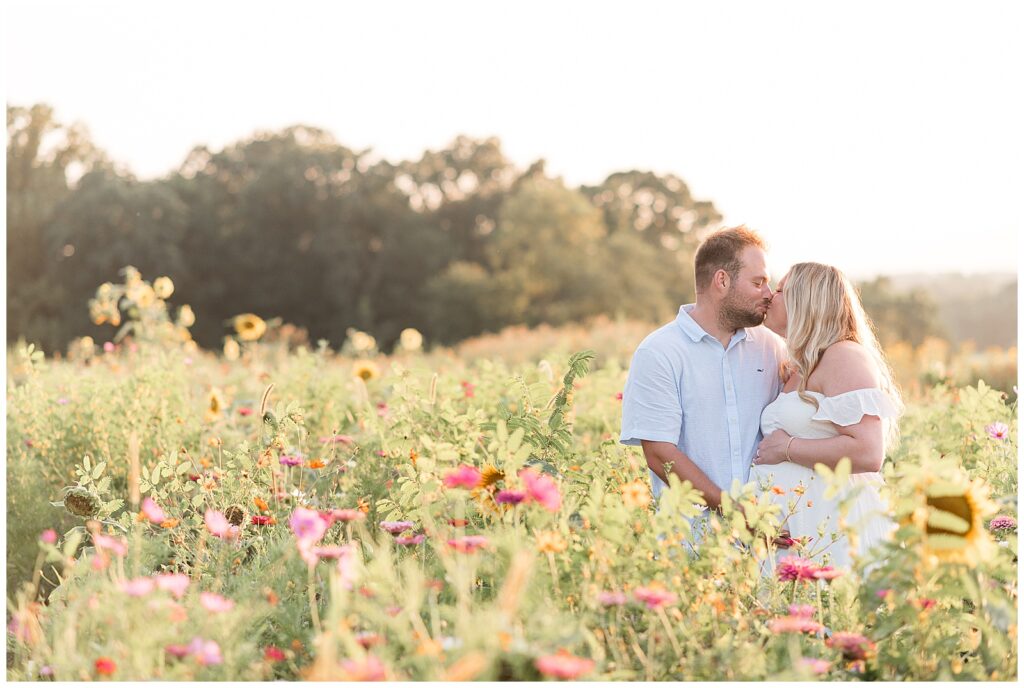 couple kissing as soon-to-be mama holds her pregnant belly for this Wildflower Overlook Maternity and Lifestyle Newborn Session