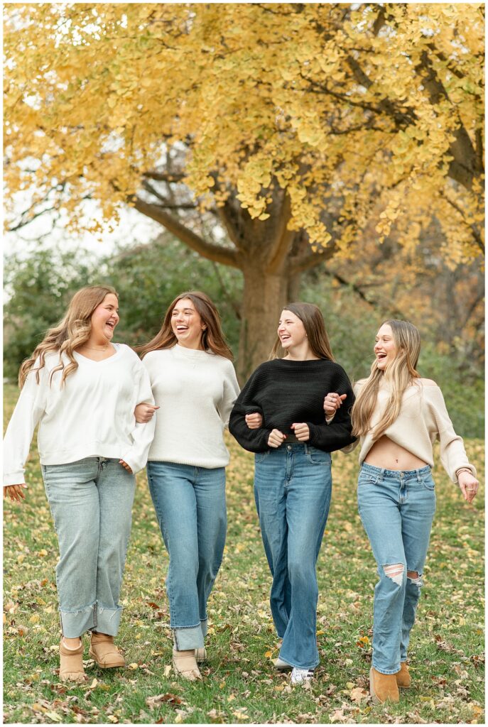 four girls with arms linked walking towards camera for this Fall Senior Team Session in York PA