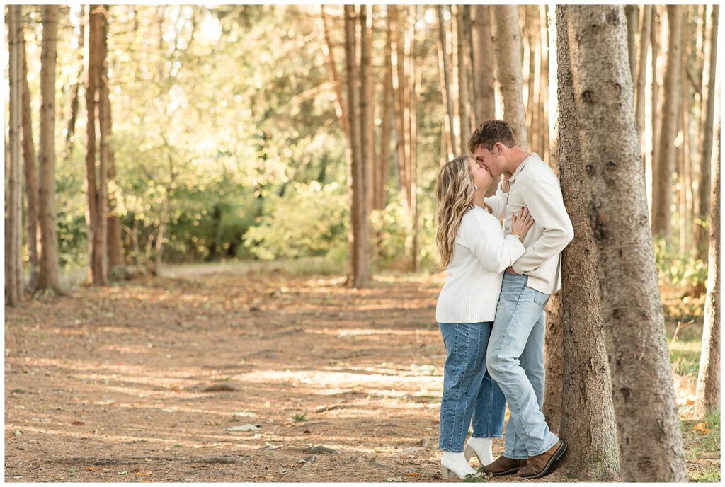 couple leaning against tree and kissing for this Overlook Park Fall Engagement Session