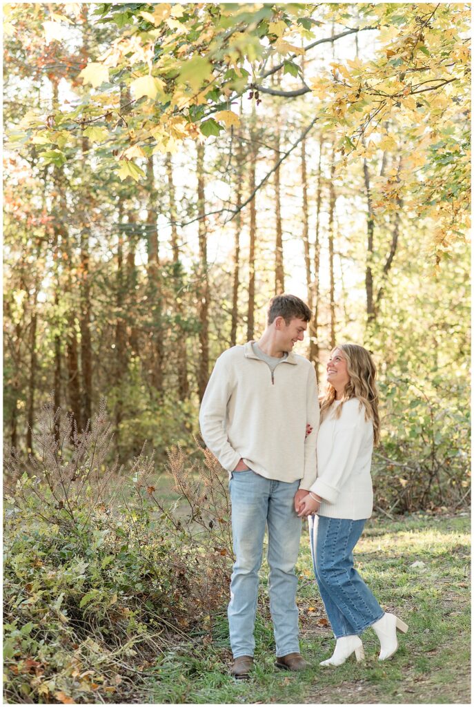 couple standing close and smiling at each other at sunset on sunny day for this Overlook Park Fall Engagement Session