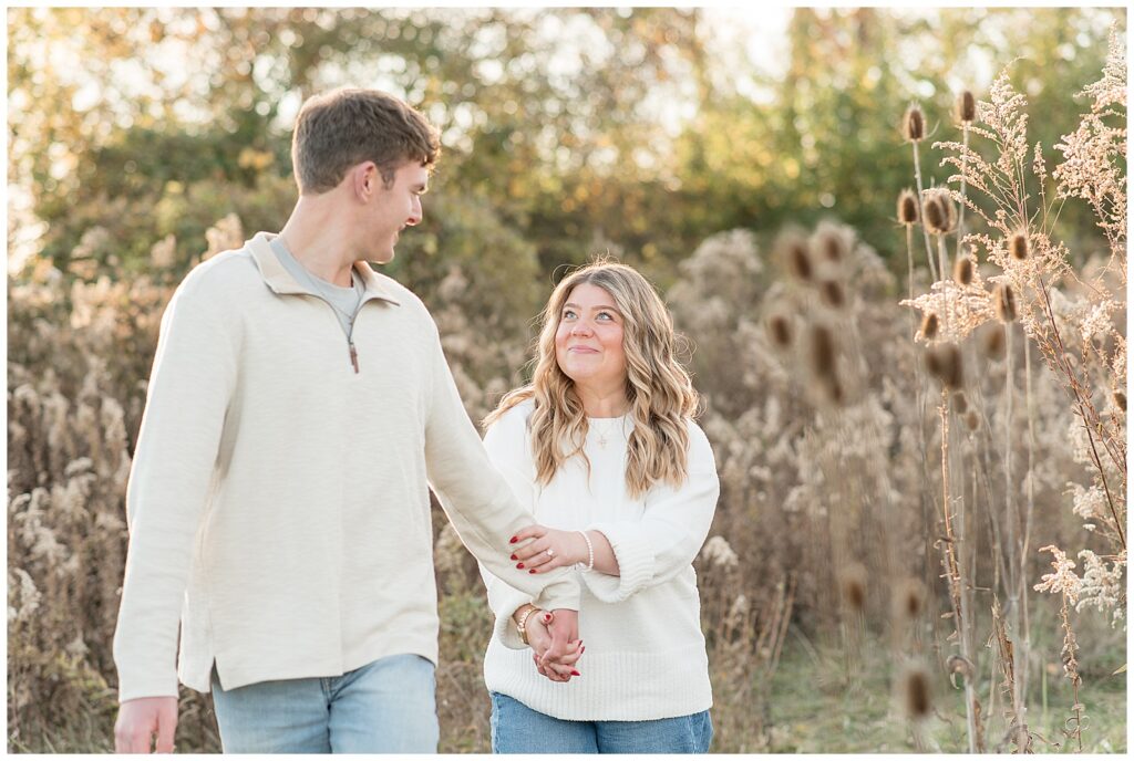 woman holding onto man's left arm as they look at each other for this Overlook Park Fall Engagement Session
