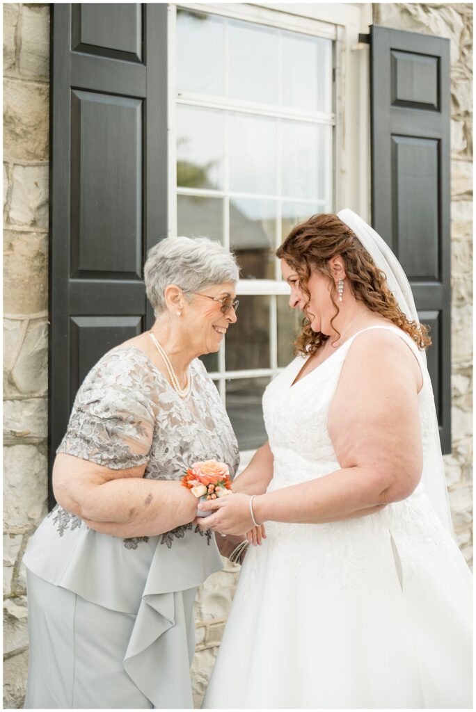 bride and her mom holding hands and looking deeply into each other's eyes for this Barn at Silverstone Fall Wedding