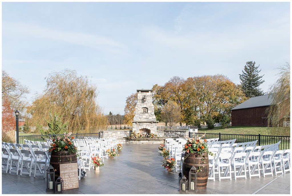 stunning outdoor ceremony space on patio with chimney for this Barn at Silverstone Fall Wedding
