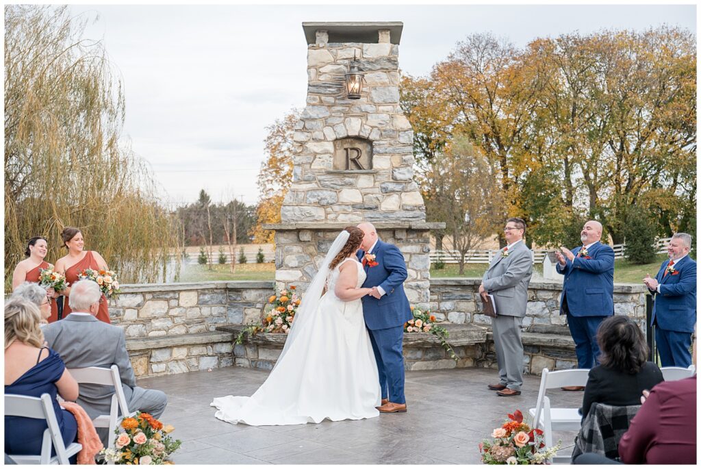 couple kissing during wedding ceremony for this Barn at Silverstone Fall Wedding