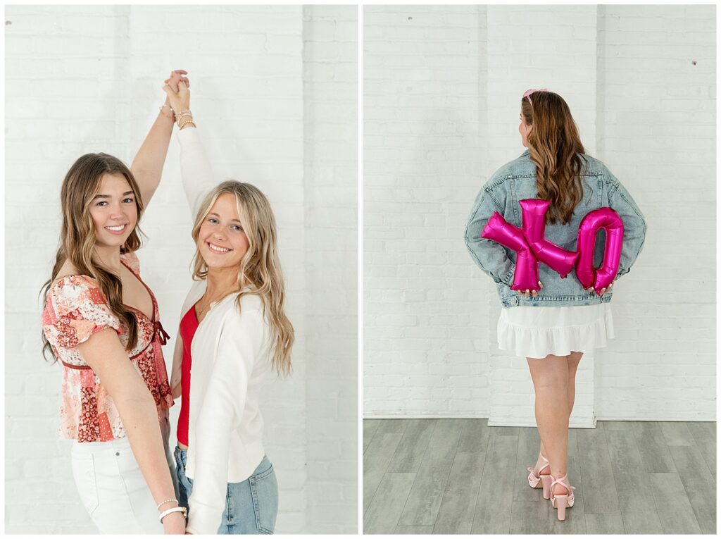 senior girls holding both hands with arms extended high in the back and also senior girl holding X and O balloons behind her back for this Valentines Day BFF Shoot