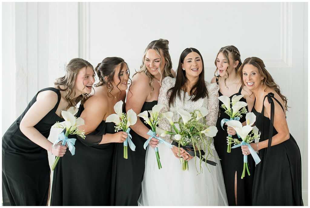 bride and her five bridesmaids huddling close together inside bridal suite for this Wedding at The Rotunda at Lauxmont Farms