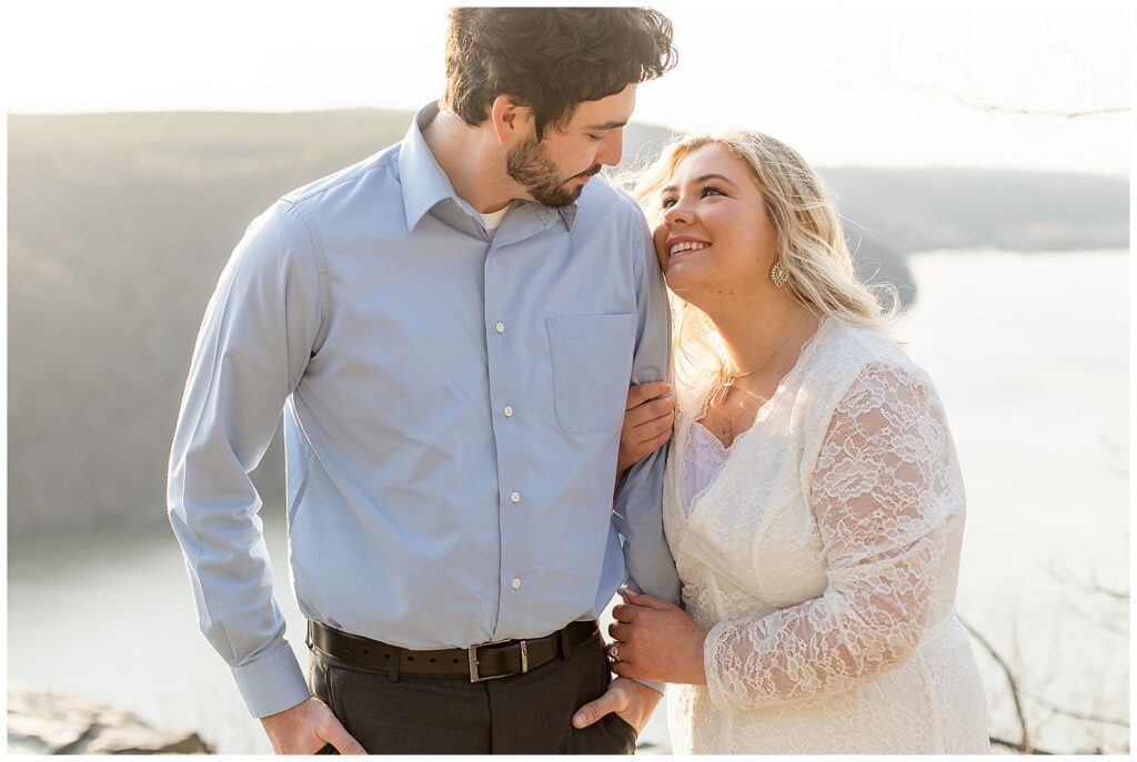 man looking at woman as she looks up at him and holds his left arm for this Pinnacle Point Spring Engagement Session