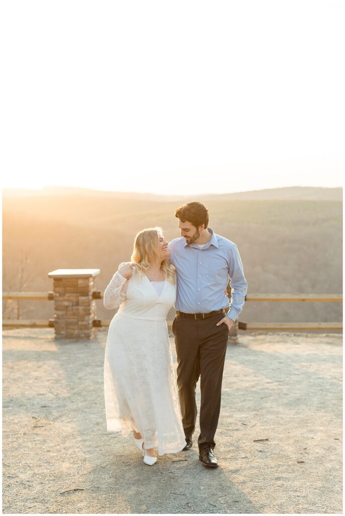 couple walking towards camera as they look at each other at bright sunset for this Pinnacle Point Spring Engagement Session