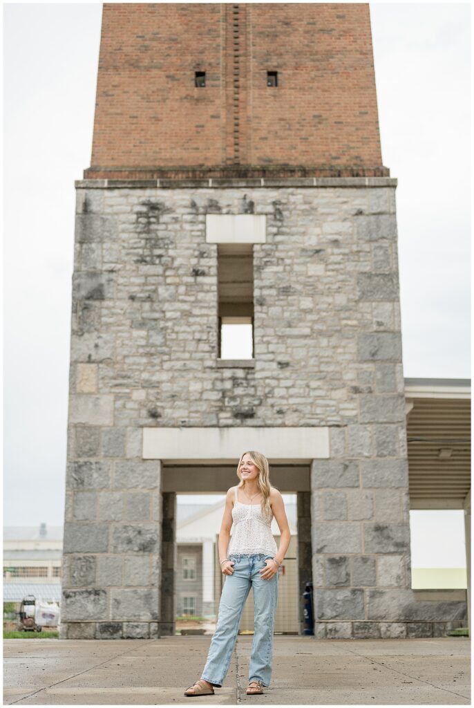 senior girl standing with hands in pocket looking to right