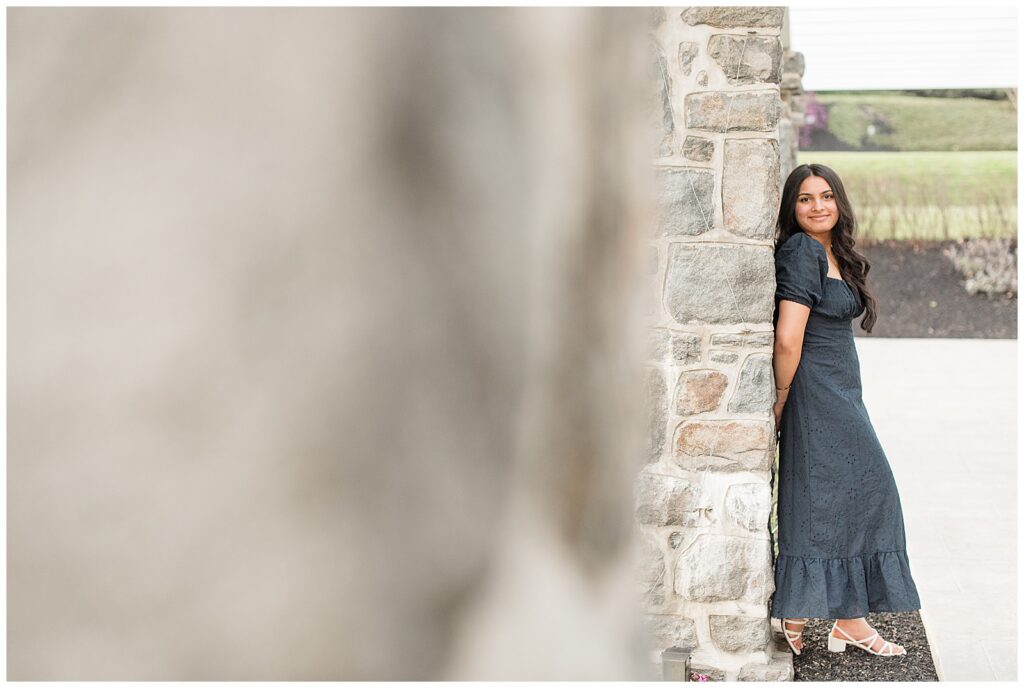 senior girl leaning against stone column for this Spring Masonic Village Senior Session