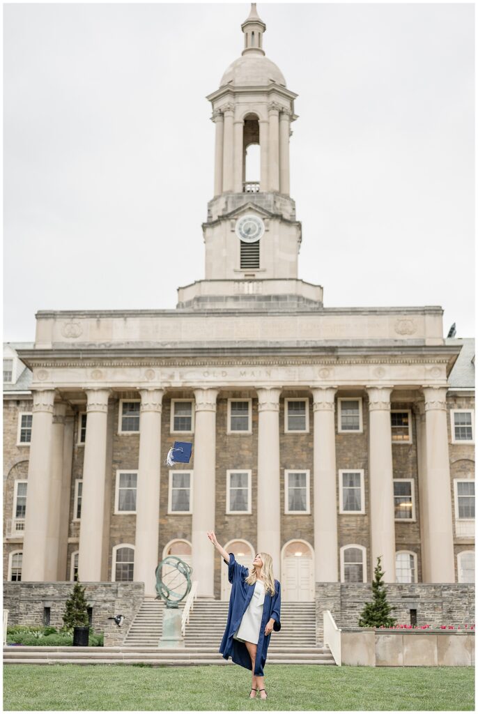 Penn State graduate throwing cap in front of Old Main