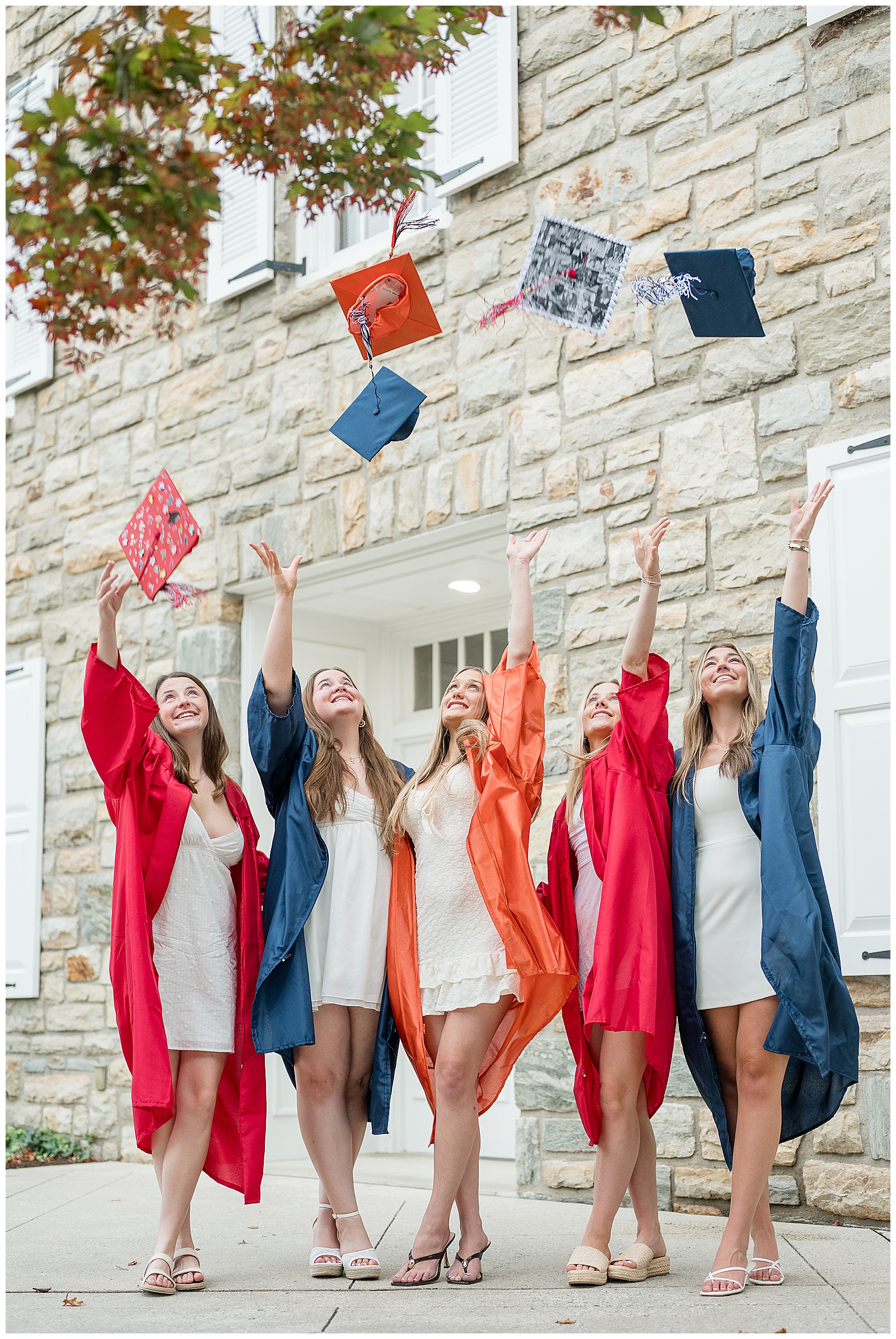 Class of 2026 spokesmodel team throwing their graduation caps into the air in Downtown Lititz, PA | Heather Marie Photography