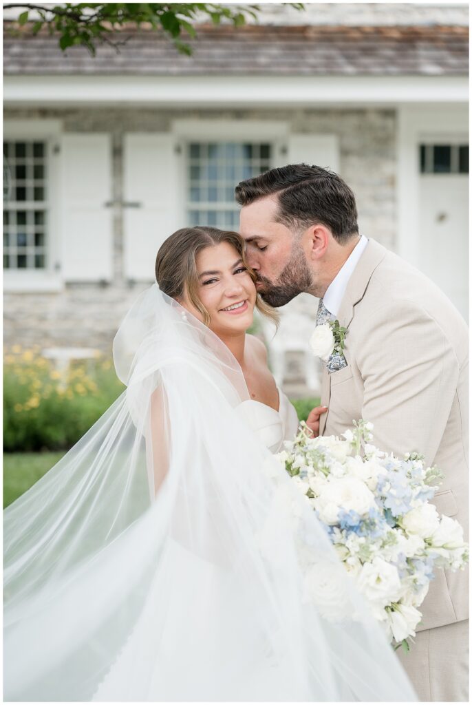 Romantic portrait of bride and groom with veil billowing, surrounded by lush summer gardens at Bluestone Estate in Willow Street, PA | Heather Marie Photography