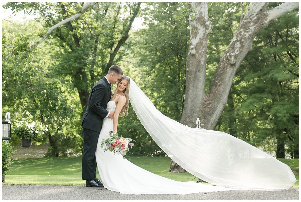 Bride and groom veil photo with cathedral veil blowing in the wind at Riverdale Manor Lancaster PA